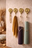 Four brass sun moon wall hooks holding yoga mats in boho yoga room, celestial wall hook set