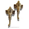 Two gold elephant head wall hooks on a white background