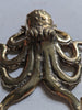 Close up of antique brass octopus hook marine animal wall decor