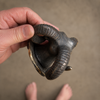 Hand holding antique brass ram wall hook from the side showing scale and size — solid brass gothic wall hook 8 inches tall handmade in Ubud Bali