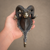 Antique brass ram wall hook held in hand showing curved hook detail from below — solid brass coat hook and towel hook handmade in Bali
