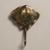 Top-down view of an antique brass stingray wall hook, showing the engraved patina finish from the set of 4 coastal hooks.