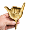 Antique brass shaka wall hook held in hand showing size and finish detail
