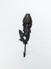 Solid brass mermaid wall hook used as a towel holder in a coastal bathroom