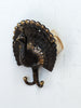 Peacock double wall hooks in antique brass finish on a white wall