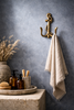 Brass anchor wall hook used as towel holder in coastal bathroom beach house decor