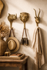 Brass lion rhino and impala wall hooks styled in luxury safari entryway decor with hanging accessories