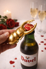 Brass beetle bottle opener used on a beer bottle in a styled bar cart setting