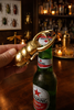 Brass beetle bottle opener on beer bottle in home bar setting, conversation piece