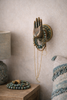 Brass Buddha mudra hand wall hook holding jewelry in a boho bedroom (size 6)