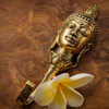 Brass Buddha wall hook flat lay styled with natural elements, Bali handmade spiritual decor