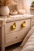 Gold brass Buddha mudra hand drawer pulls on a wooden dresser in boho home decor