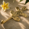 Close-up flat lay of a solid brass cactus wall hook with a frangipani flower, highlighting the handcrafted texture and boho desert design.