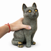 Hand holding solid brass cat sculpture to show size and weight of brass animal figurine