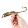 Angled view of brass conch shell hook showing sculptural coastal decor design
