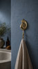 Nautical brass conch shell hook styled on blue wall coastal bathroom towel holder