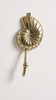 Brass conch shell wall hook mounted on wall as coastal bathroom towel hanger