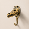 Solid brass crocodile alligator skull wall hook mounted on a beige wall showing full sculptural antique brass jaw and teeth detail — gothic dark academia wall hook handmade in Ubud Bali