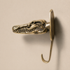 Side profile of solid brass crocodile alligator skull wall hook on a beige wall showing jaw depth and hook detail — antique brass gothic wall hook handmade in Ubud Bali
