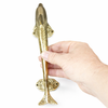 Brass dolphin door handle held vertically in hand for scale, nautical coastal door hardware.