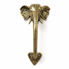 Full length solid brass elephant trunk door handle on clean white background showing complete product from detailed elephant head with large ears and curved tusks at top through coiled segmented brass trunk body down to ornate heart shaped decorative base plate at bottom. Warm antique gold brass finish throughout entire handle. Handcrafted unique elephant door pull and antique entry door handle for boho home decor and housewarming gift. Made by professional artisans in Bali.