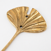 Angled flat lay of gold brass fan leaf wall hook showing warm gold finish, detailed fan leaf vein texture and stem detail against clean background. Handcrafted leaf shaped plant hanger hook, towel hook and coat hook for boho home decor, plant lover housewarming gift and nature-inspired botanical wall decor. Slow made in Bali from recycled brass