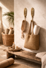 Brass feather wall hooks used for towels and bag storage in a warm neutral interior