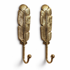 Set of two brass feather wall hooks in gold finish on white background