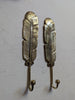 Pair of brass feather wall hooks in antique finish mounted on wall