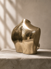 Gold brass female torso sculpture at a side angle in warm ambient light — after dark decor and man cave decor gold body sculpture, eclectic home decor gift for him handcrafted in Bali