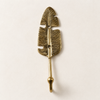 Brass Fern leaf wall hook mounted on a neutral wall, handmade nature-inspired hook with feathered leaf design.