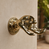Close-up of a brass fingering hand wall hook showing the detailed hand sculpture and cheeky statement decor design.