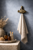 Brass fish wall hook used as towel holder in coastal bathroom beach house decor setting