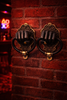 Brass fist wall sculpture pair mounted on brick wall, moody statement wall art for dramatic and after dark home decor