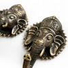 Two brass Ganesha wall hooks in gold polished finish displayed with fresh white and yellow frangipani flowers showing Balinese cultural styling and artisan craftsmanship. Handcrafted Buddhist elephant wall hook for boho home decor, yoga room decor, meditation decor and housewarming gift. Created with reverence by professional Hindu artisans in Bali