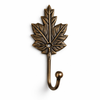 Single brass grape leaf wall hook in antique finish on white background