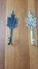 Brass grape leaf wall hooks in gold and antique finishes displayed on wooden surface