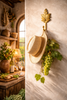 Brass grape leaf wall hook styled in a warm rustic interior with hat and greenery