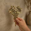 Close view of brass grape wall hook in hand, vintage brass finish, decorative towel hook for rustic kitchen