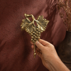 brass grape wall hook held against wall, vintage towel hook for wine kitchen decor, rustic vineyard home accent