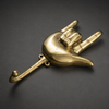 Angled view of a brass hand gesture wall hook, showing the rock on hand shape and heavy metal wall decor design.