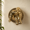 Close-up of the wall-mounted base of a brass fingering hand hook, showing the polished brass finish and hardware detail.