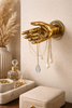 Brass hand wall mount holding necklaces as a jewelry holder