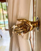 Brass handshake wall mount used as a curtain holdback in a boho interior