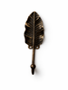 Single brass leaf wall hook in antique finish on white background