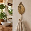 Brass leaf wall hook holding a folded towel in a boho bathroom, handmade botanical key hanger and coat hook