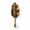 Brass leaf wall hook in gold finish on white background for minimalist nature decor