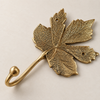 Front angled view of brass maple leaf wall hook in a polished gold finish