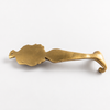 Solid brass mermaid double wall hook laid flat on beige surface showing full tail and double hook detail from above — brass mermaid coastal home decor handmade in Ubud Bali