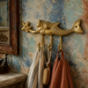 Brass mermaid wall hook with 3 connected hooks mounted near a mirror, holding towels and scarves as coastal wall decor.